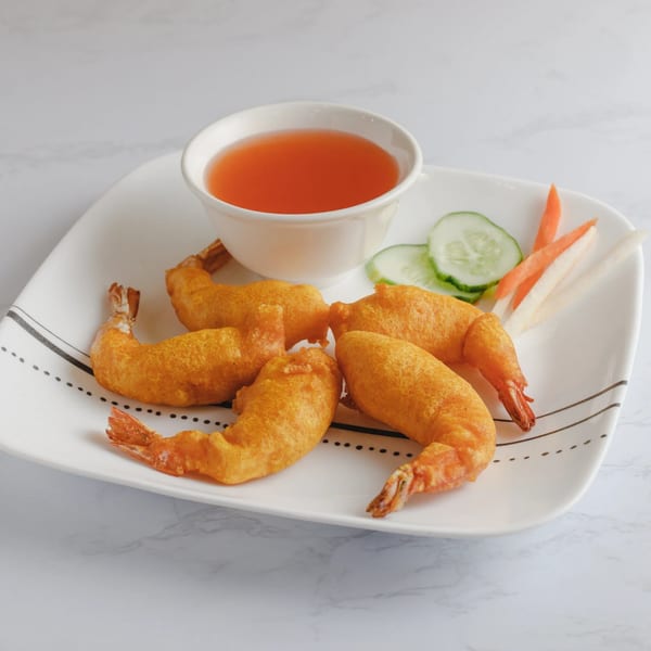 Five golden-fried shrimp with a side of sweet chili sauce, cucumber, and pickled carrots.